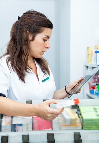 Young female pharmacist at his store.